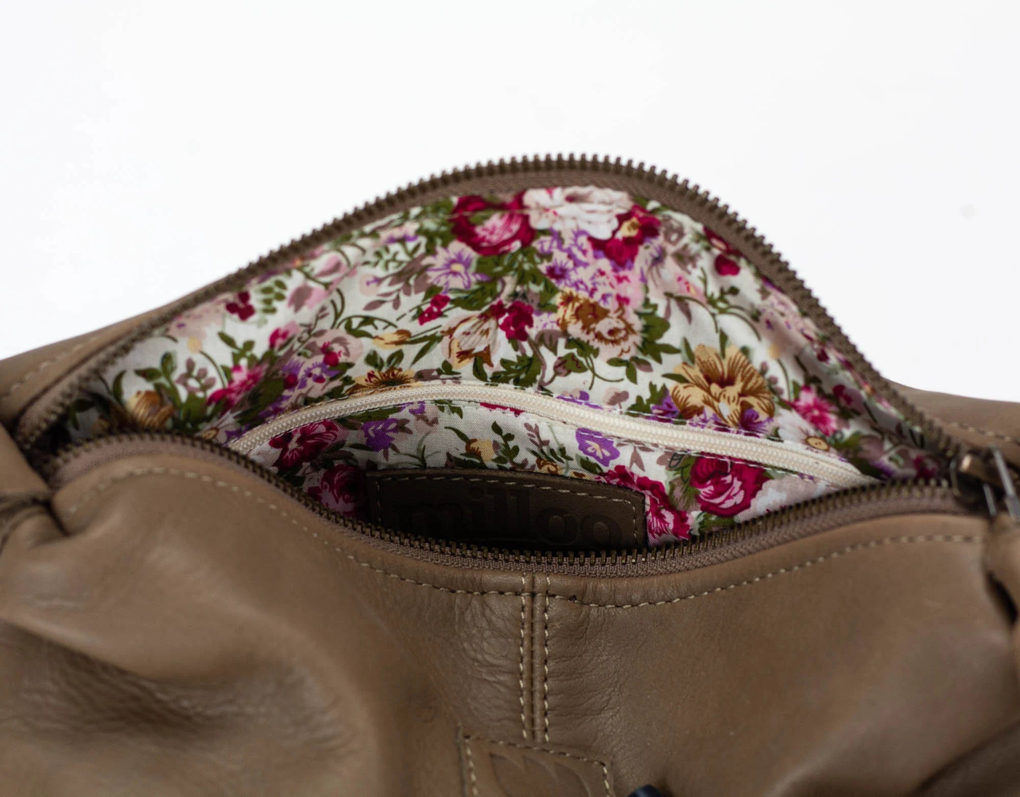 Close-up of a brown leather bag with a floral interior lining.