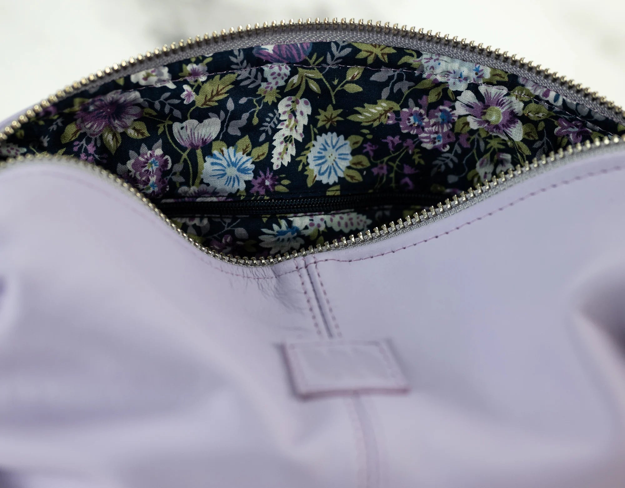 Close-up of a purple garment with floral lining inside a zipper pocket.