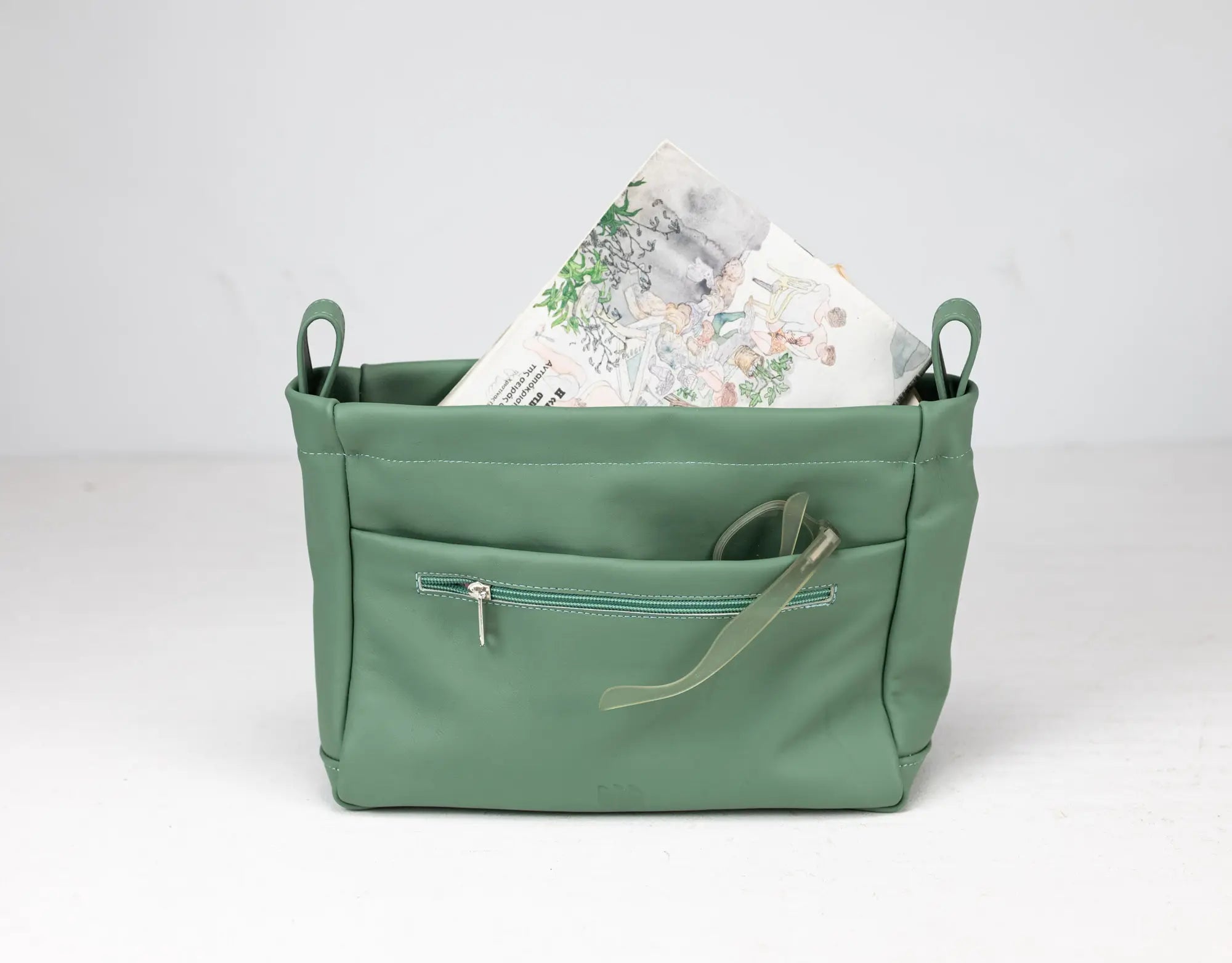 Green bag with a zipper pocket on a white background