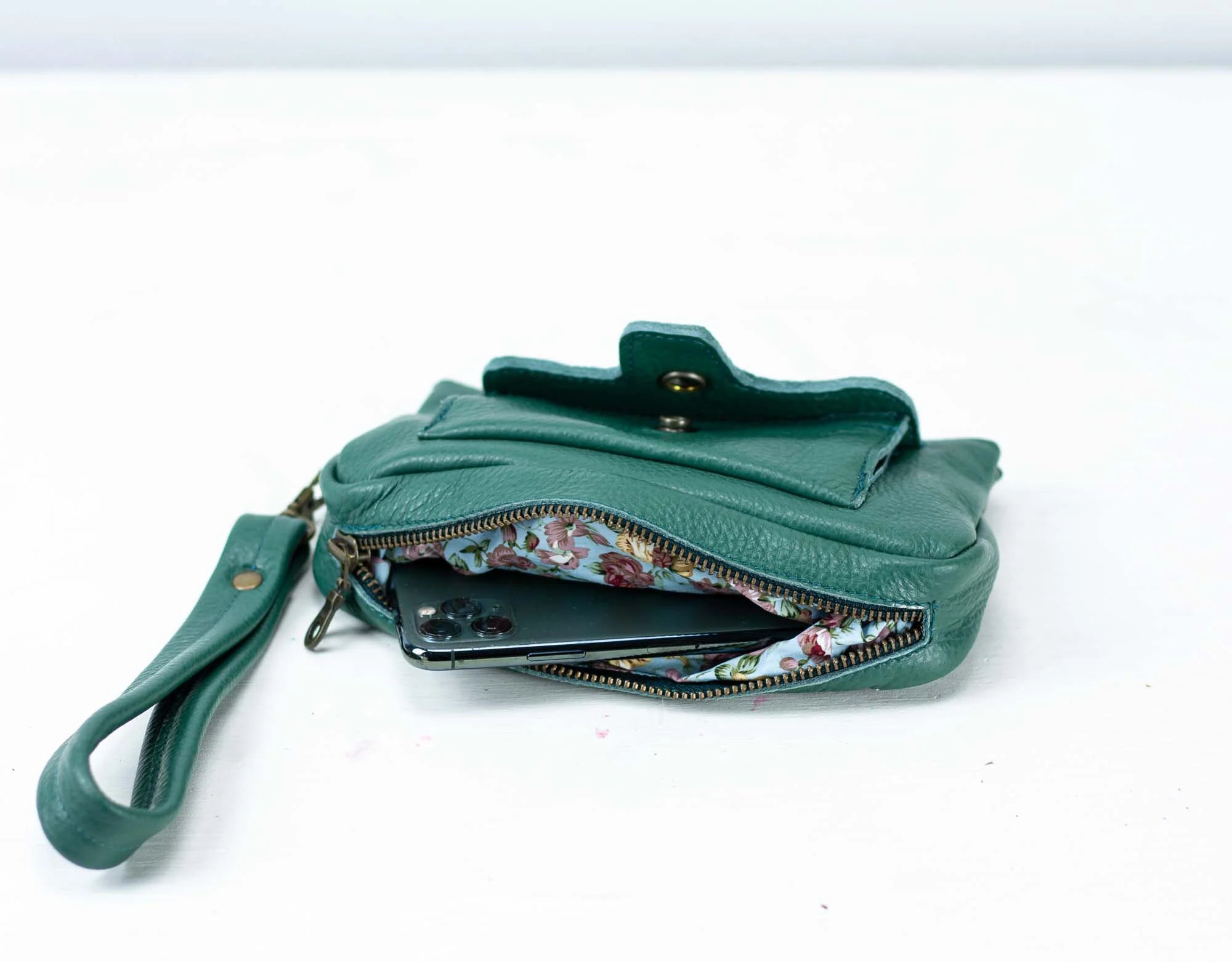 Green handbag with floral interior on a white background