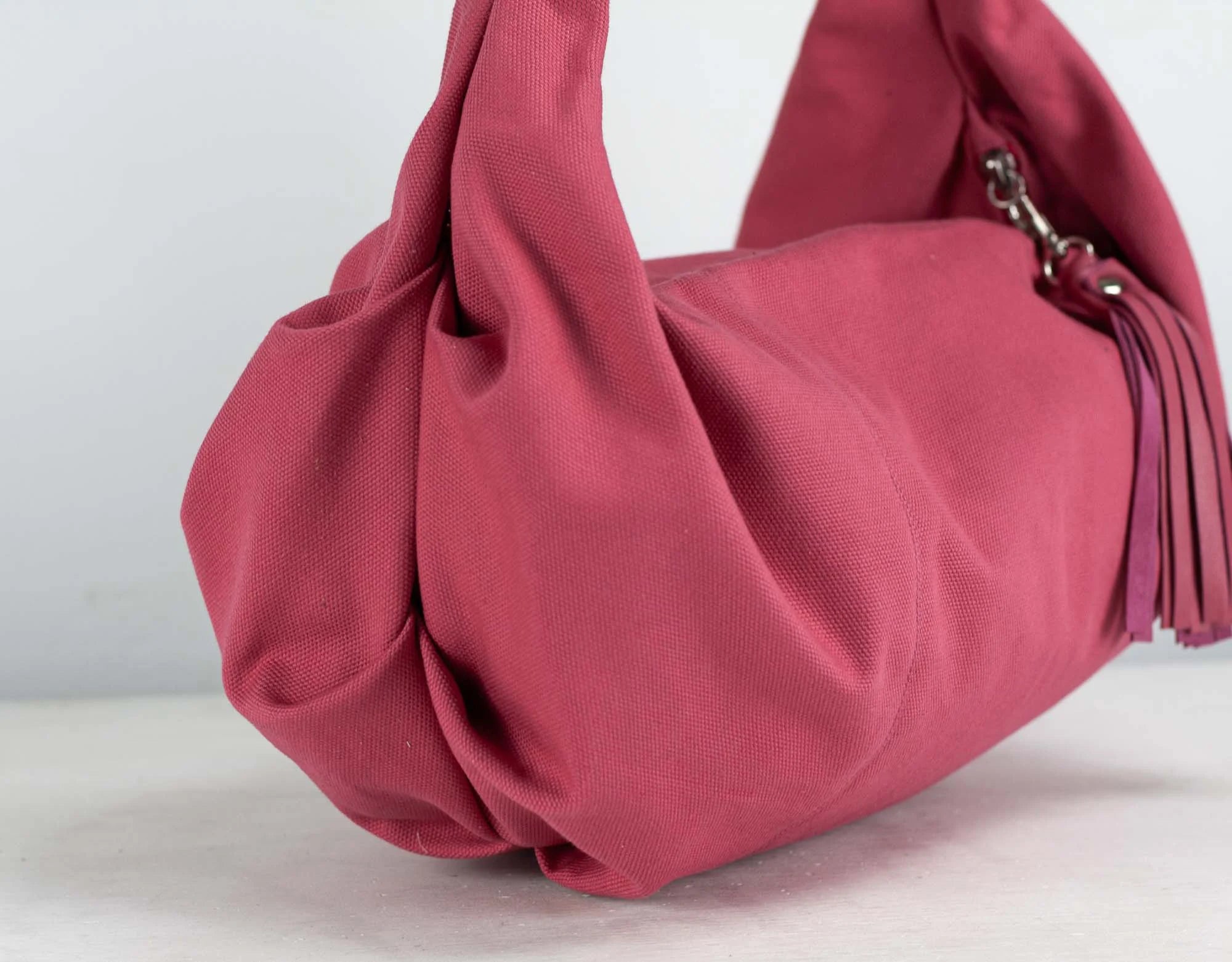 Pink handbag with a tassel on a white background