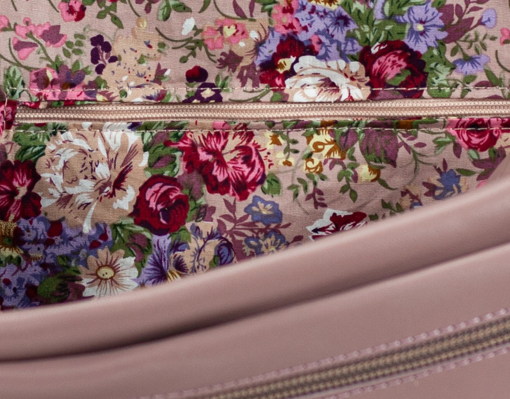 Floral-patterned fabric with a zipper on a pink background