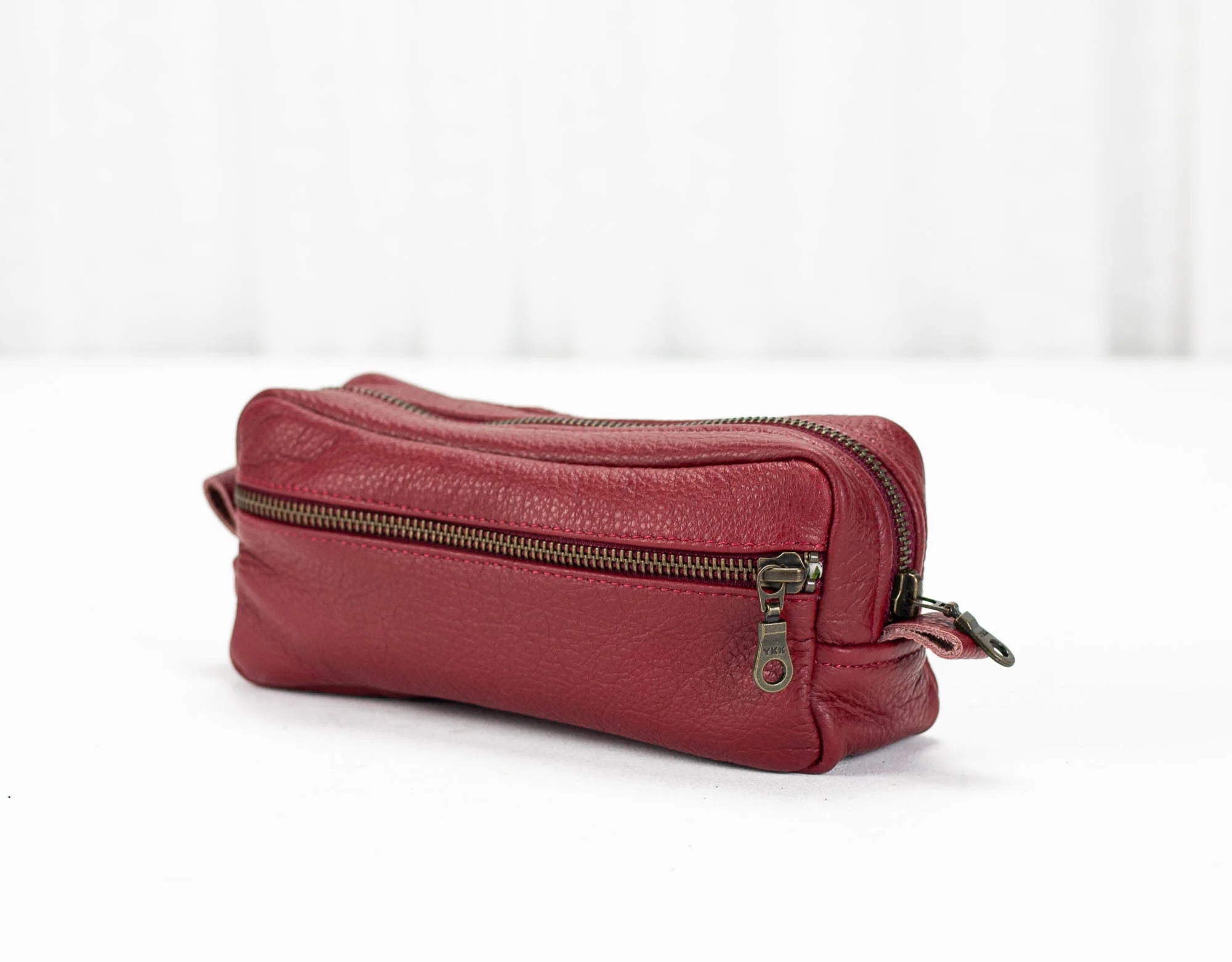Red leather pouch with a zipper on a white background