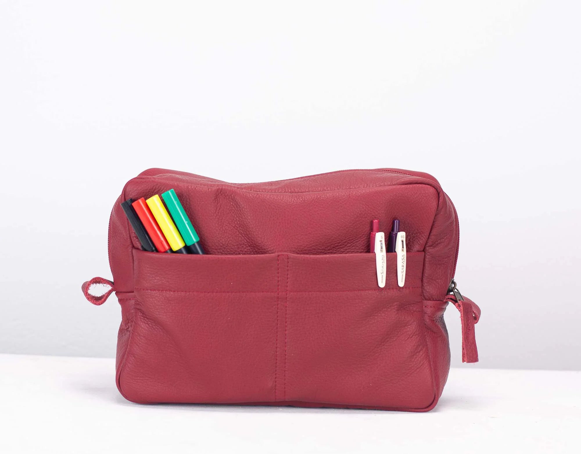 Red pouch with compartments and colorful items on a white background