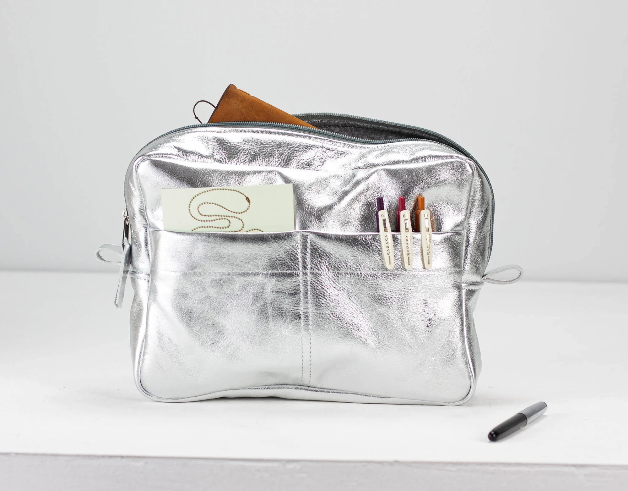 Silver pouch with a brand logo on a white background