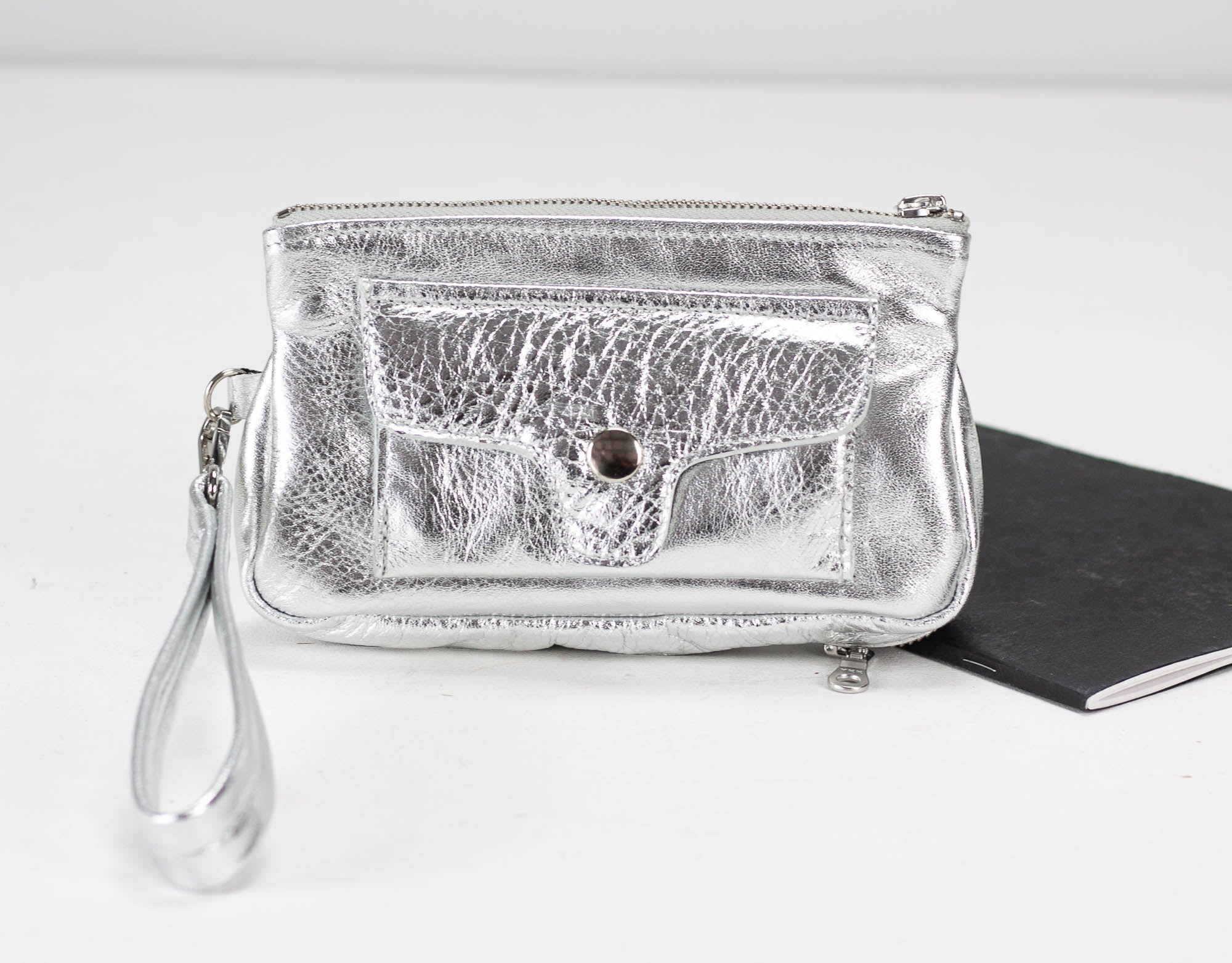 Silver clutch bag with a textured surface on a white background