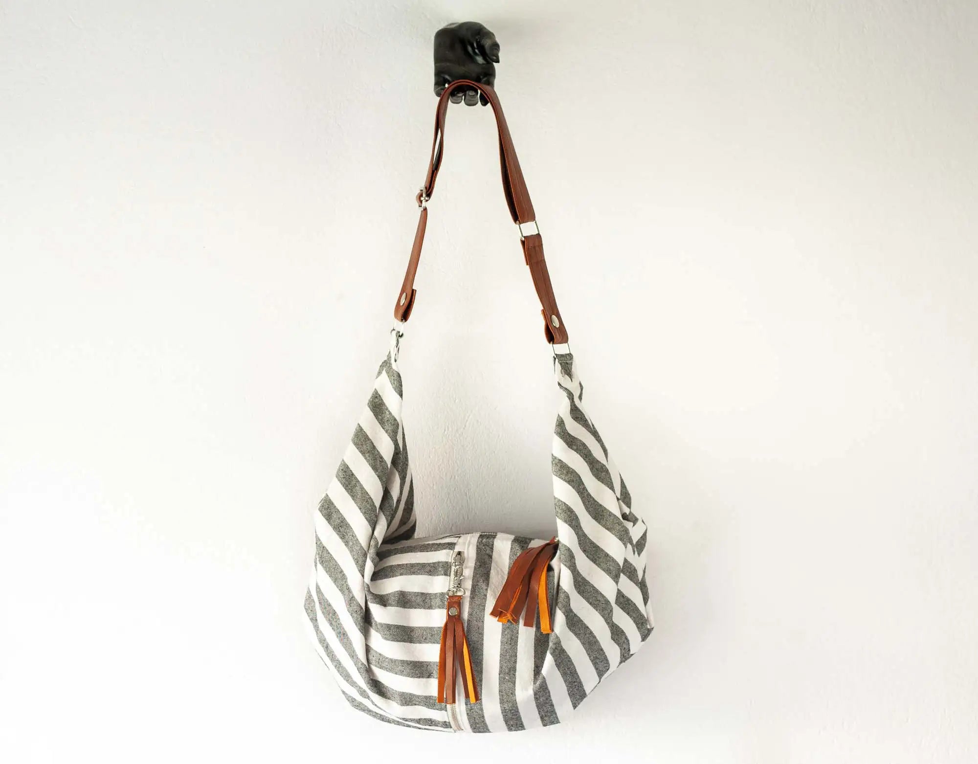 Striped bag with brown leather straps on a white background
