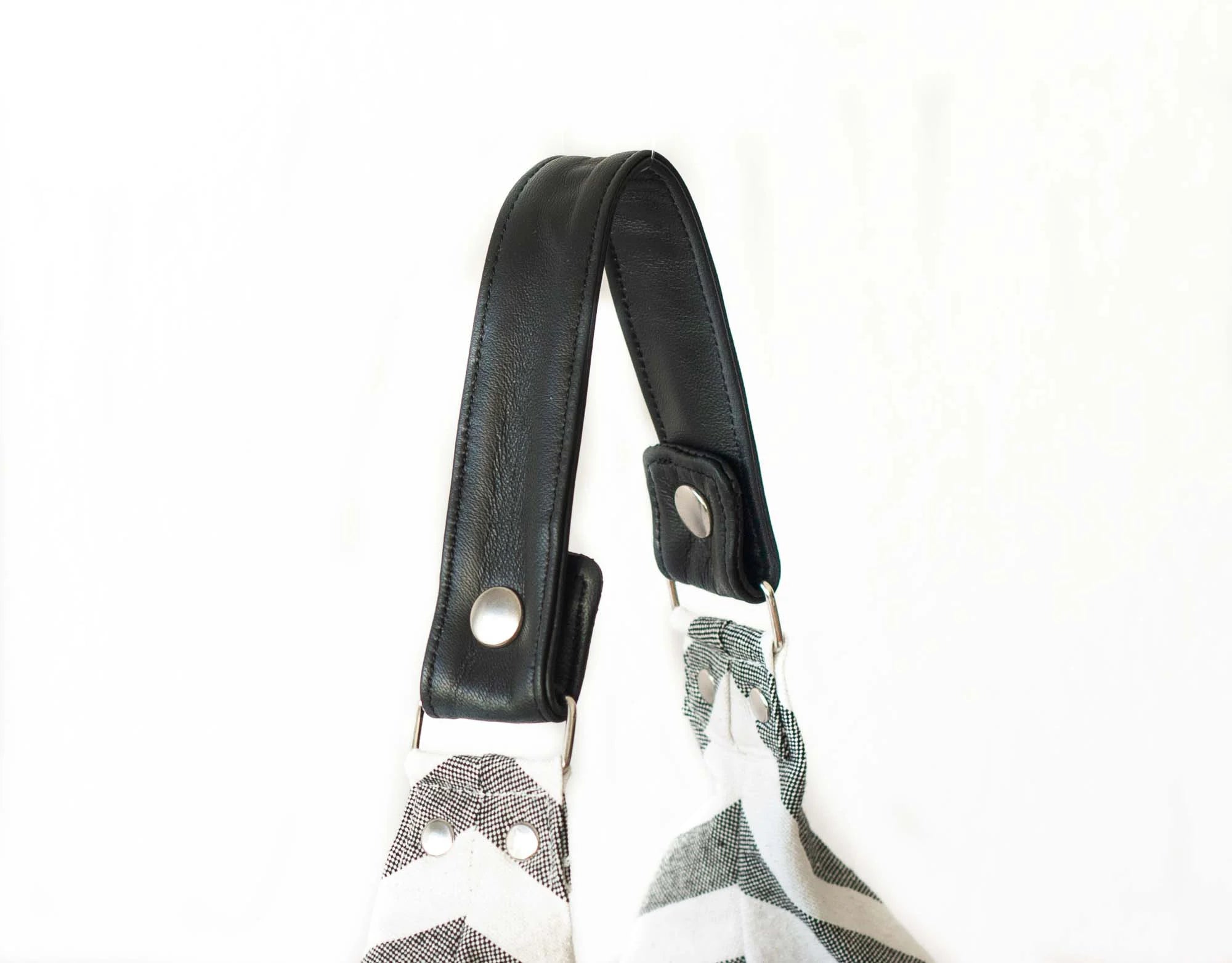 Black strap with metal buckles on a white background