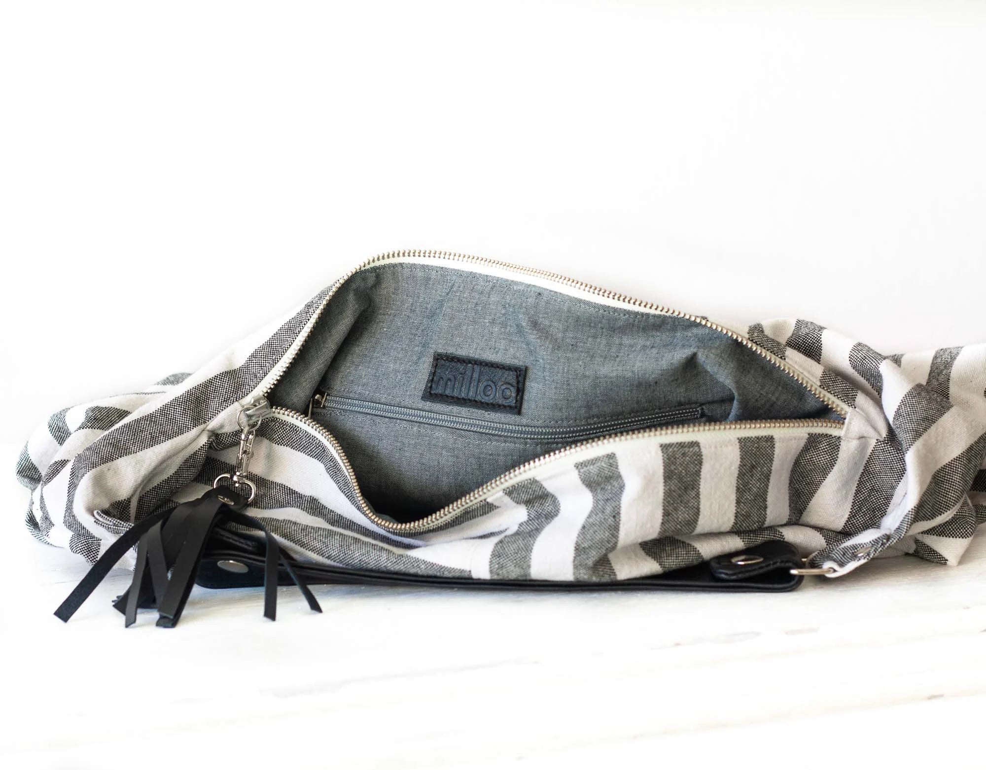 Gray and white striped bag with a zipper on a white background