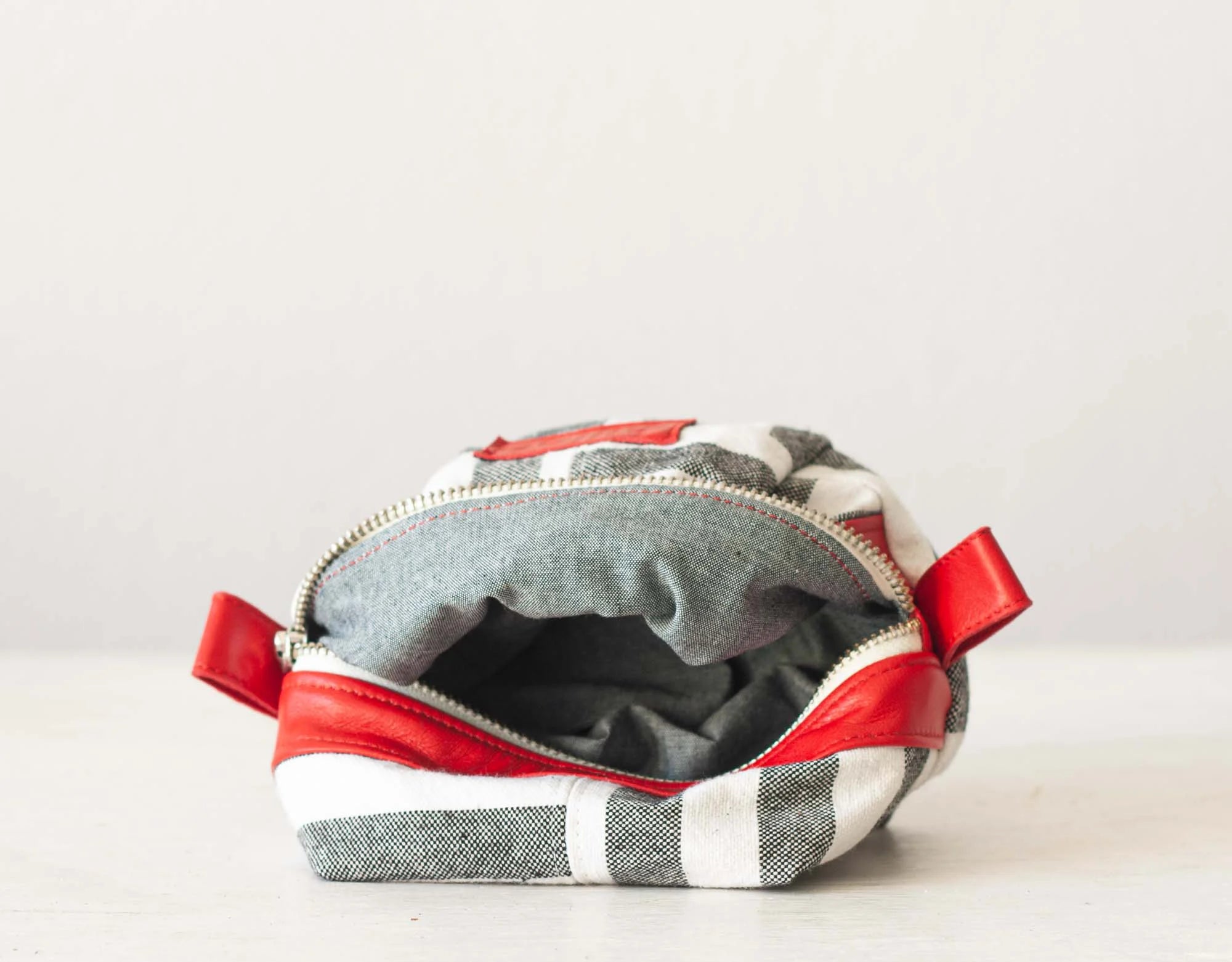 Fabric pouch with red zipper on a white background