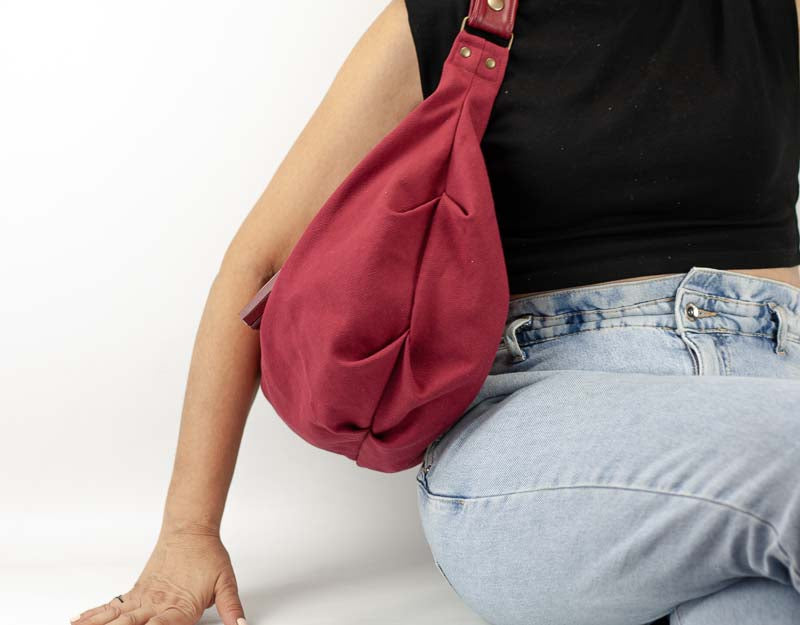 Person wearing a red shoulder bag on a white background