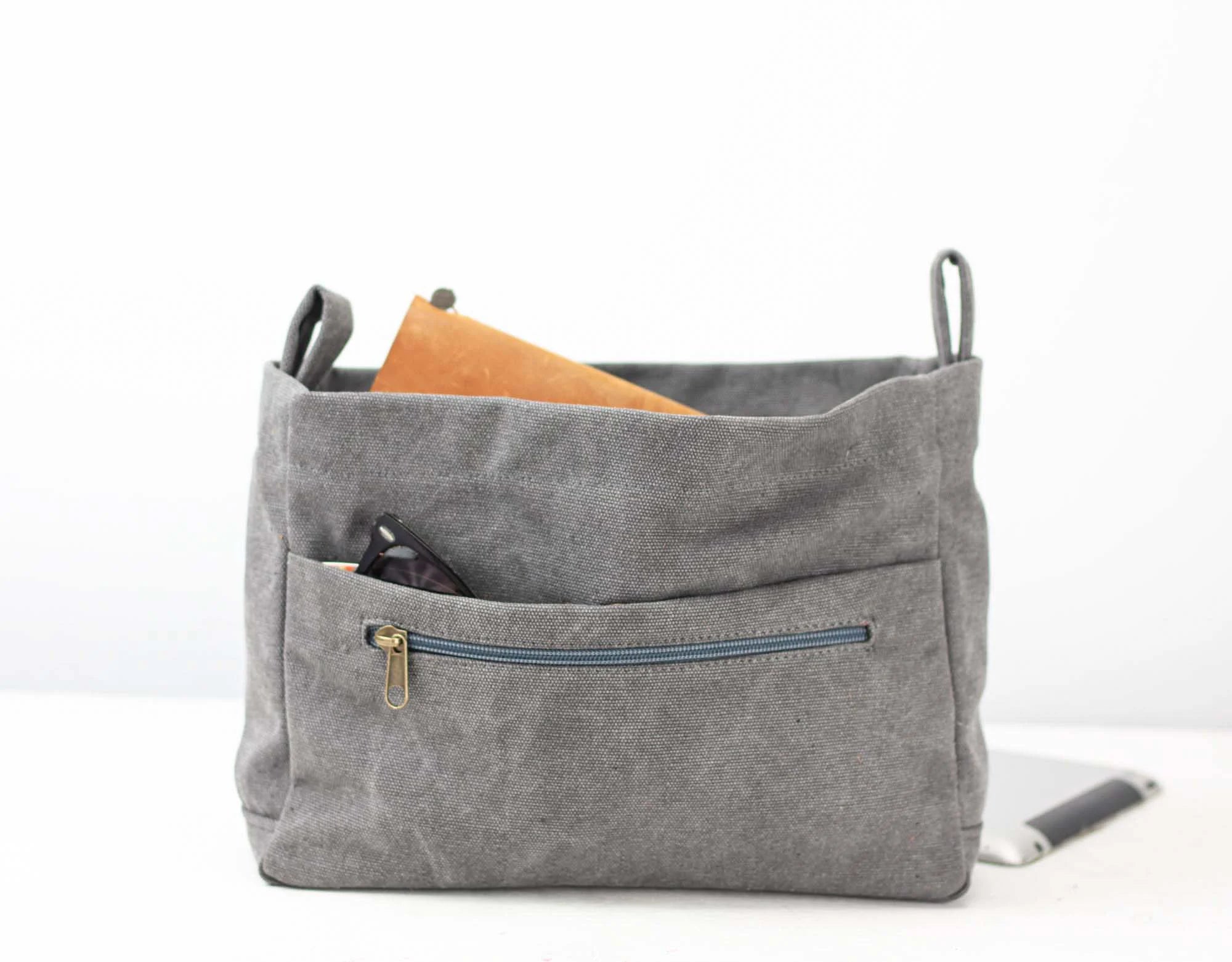 Gray fabric bag with a zipper pocket on a white background