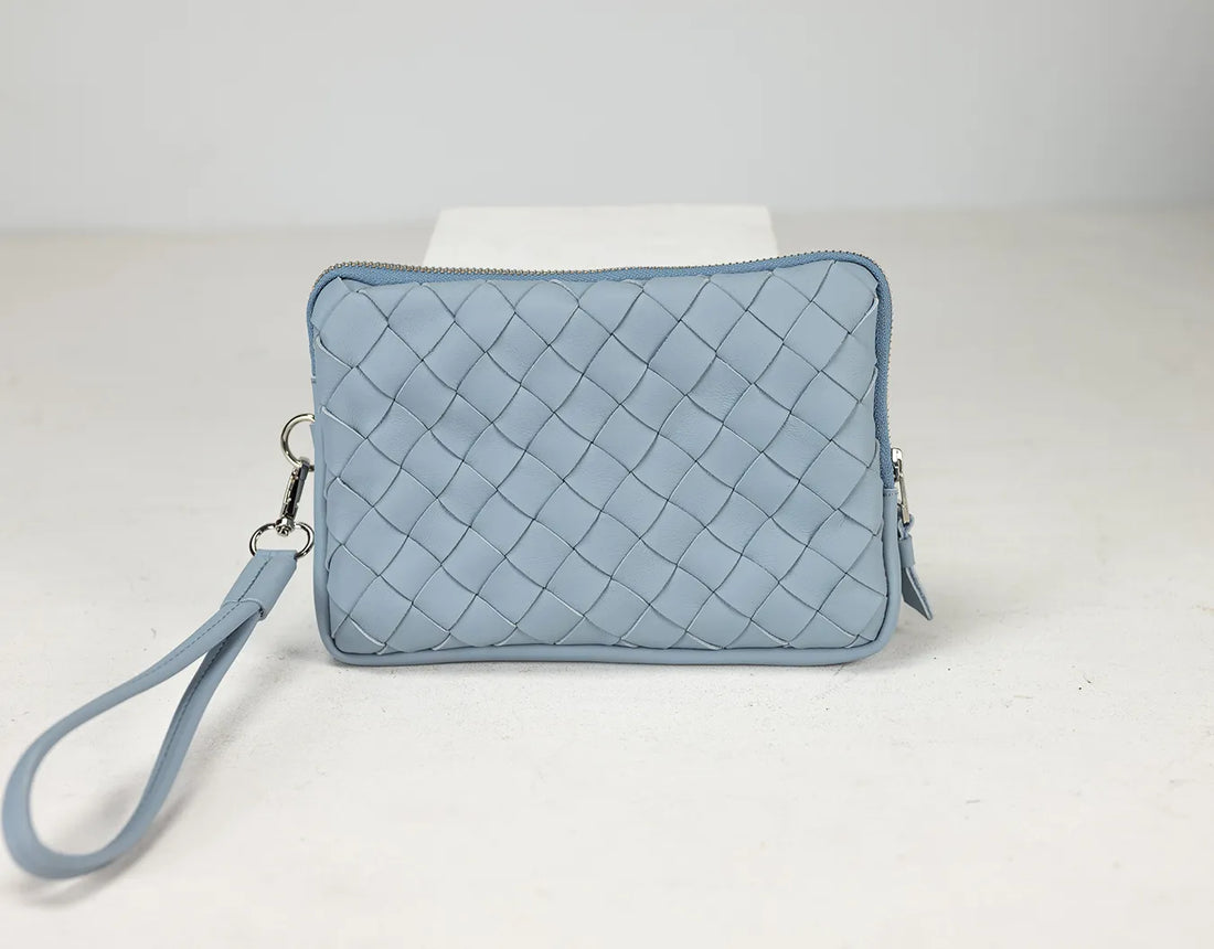 Light blue quilted clutch bag on a white background
