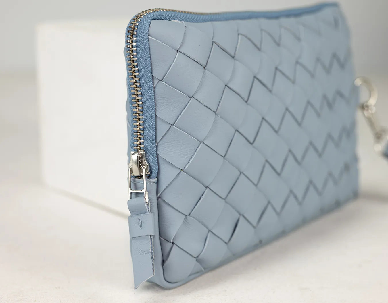 Blue woven clutch bag on a light background
