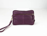 Purple leather clutch bag with a strap on a white background