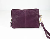 Purple leather bag with a gold zipper on a white background