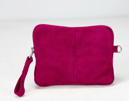 Pink suede pouch with a wrist strap on a white background