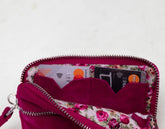 Pink floral-patterned wallet with zipper on a white background