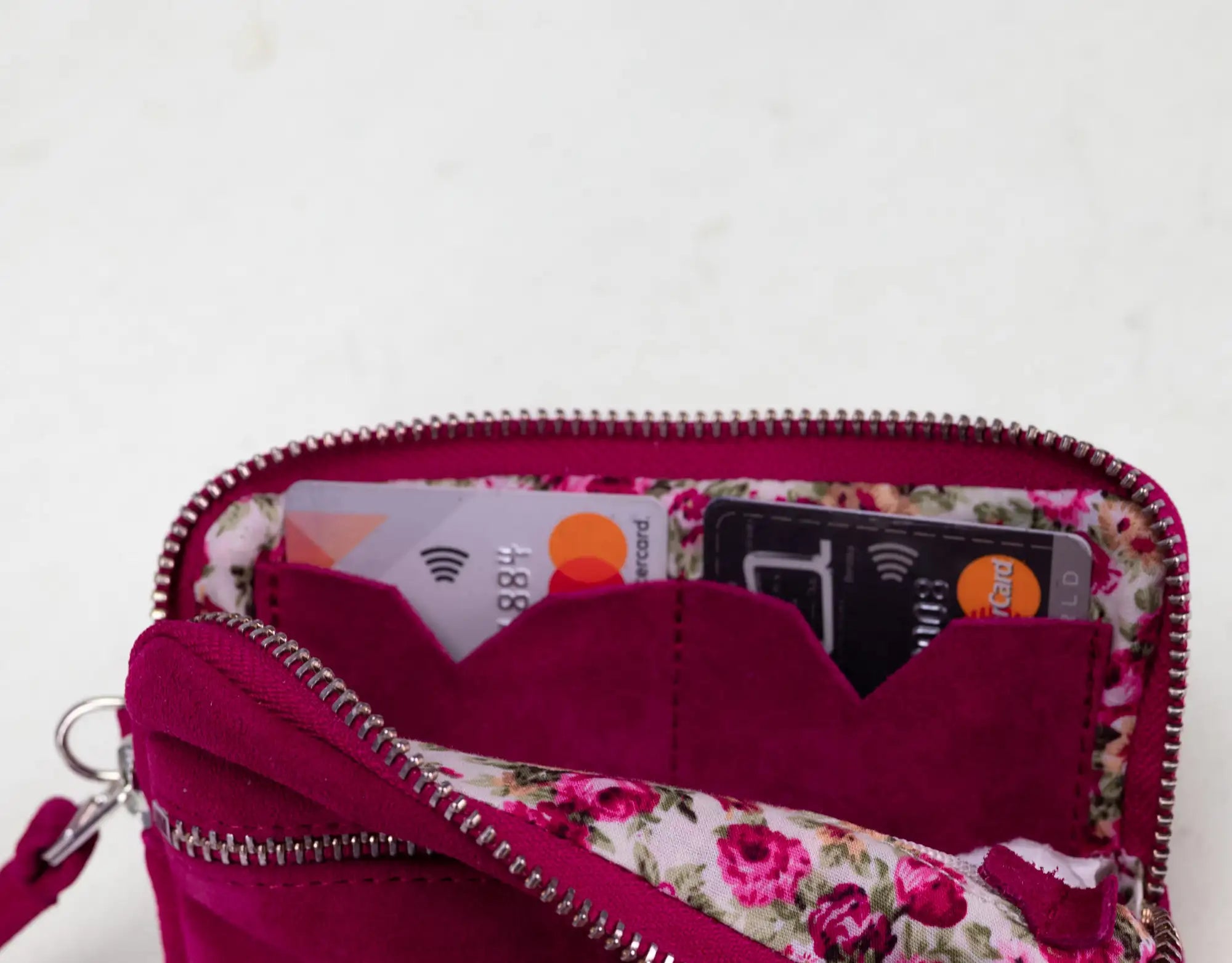 Pink floral-patterned wallet with zipper on a white background