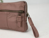 old rose leather clutch with a strap on a white background