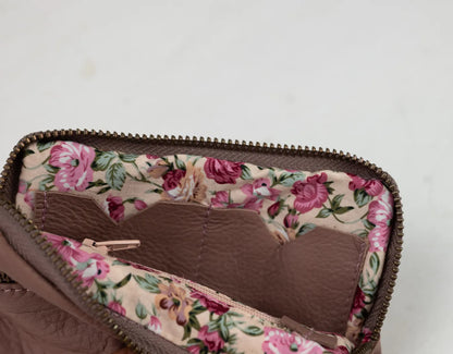 Floral-patterned fabric lining a brown bag on a light gray background