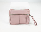 Pink wristlet with a zipper on a white background