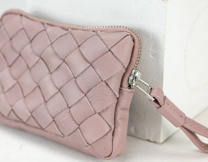 Pink quilted wallet with a strap on a light background