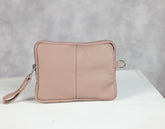 Pink pouch with a strap on a white surface and gray background