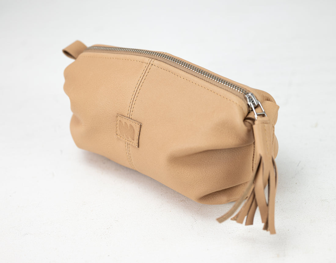 Beige pouch with a zipper and tassels on a white background