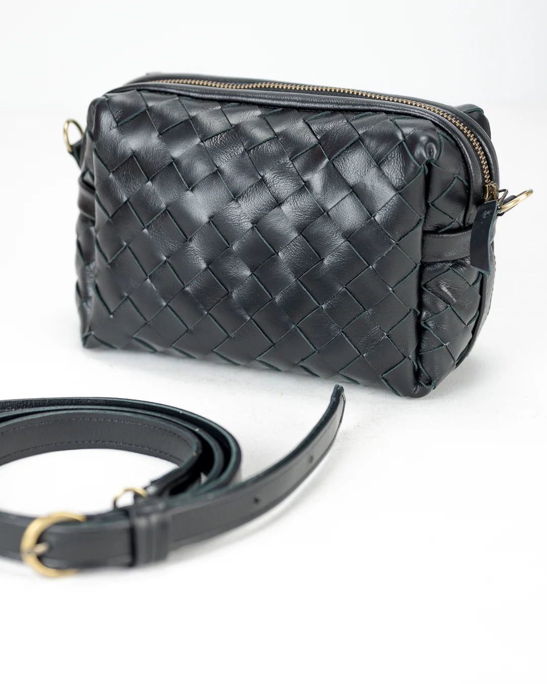 Black woven handbag with a matching strap on a white background