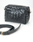 Black woven handbag with a matching strap on a white background