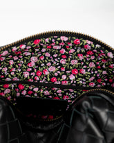 Black bag with pink floral pattern on a white background