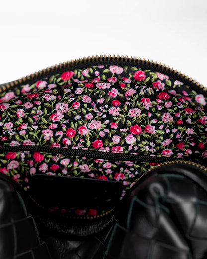 Black bag with pink floral pattern on a white background