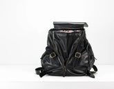 Black leather backpack with gold buckles on a white background