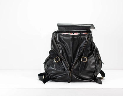 Black leather backpack with gold buckles on a white background