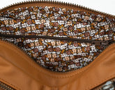 Close-up of a brown leather bag with a floral patterned interior.