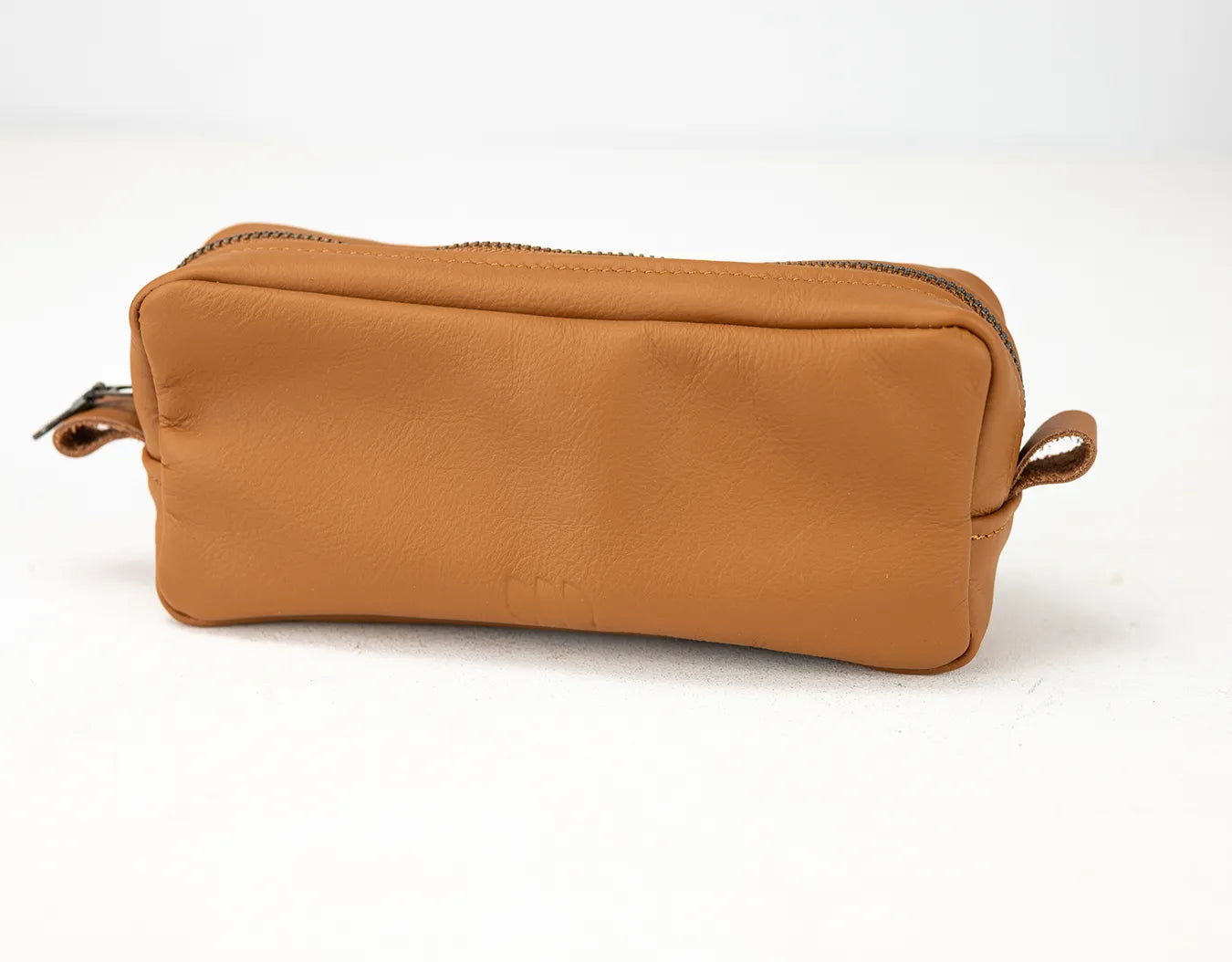 Brown leather toiletry bag on a white background