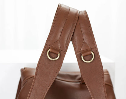 Brown leather bag with gold rings on a white background