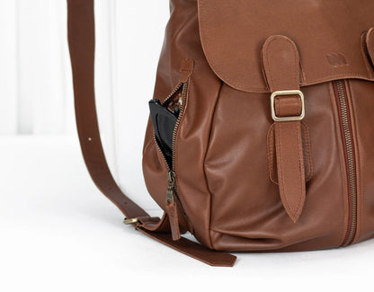 Brown leather backpack with gold buckle on a white background