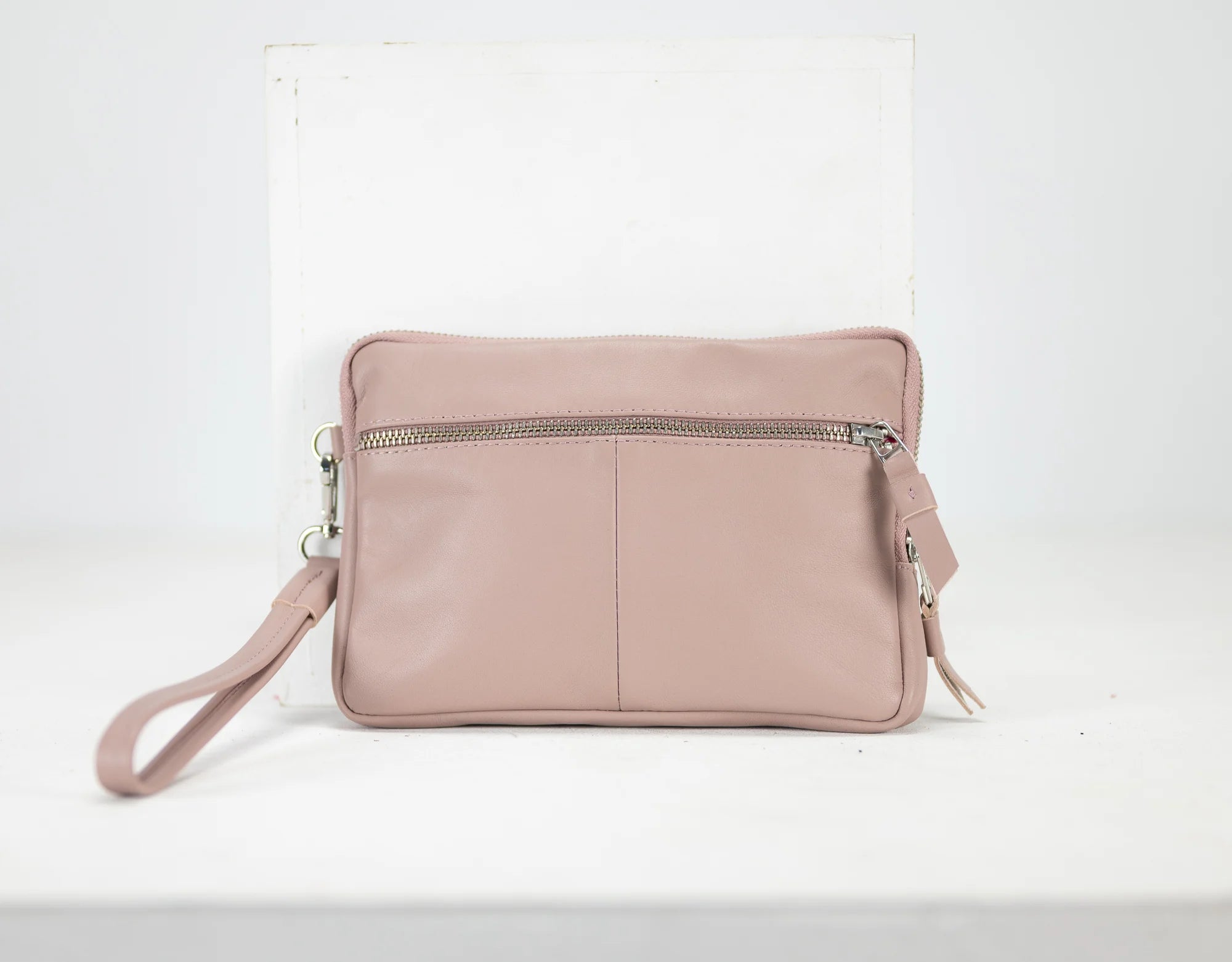 Pink leather crossbody bag on a white background