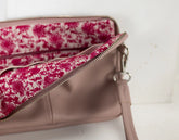Pink floral-patterned clutch bag on a white background