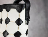 Handbag with soccer ball pattern on a gray background