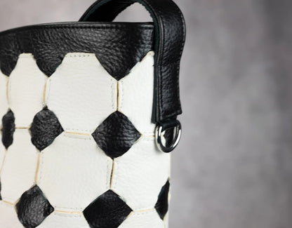 Handbag with soccer ball pattern on a gray background