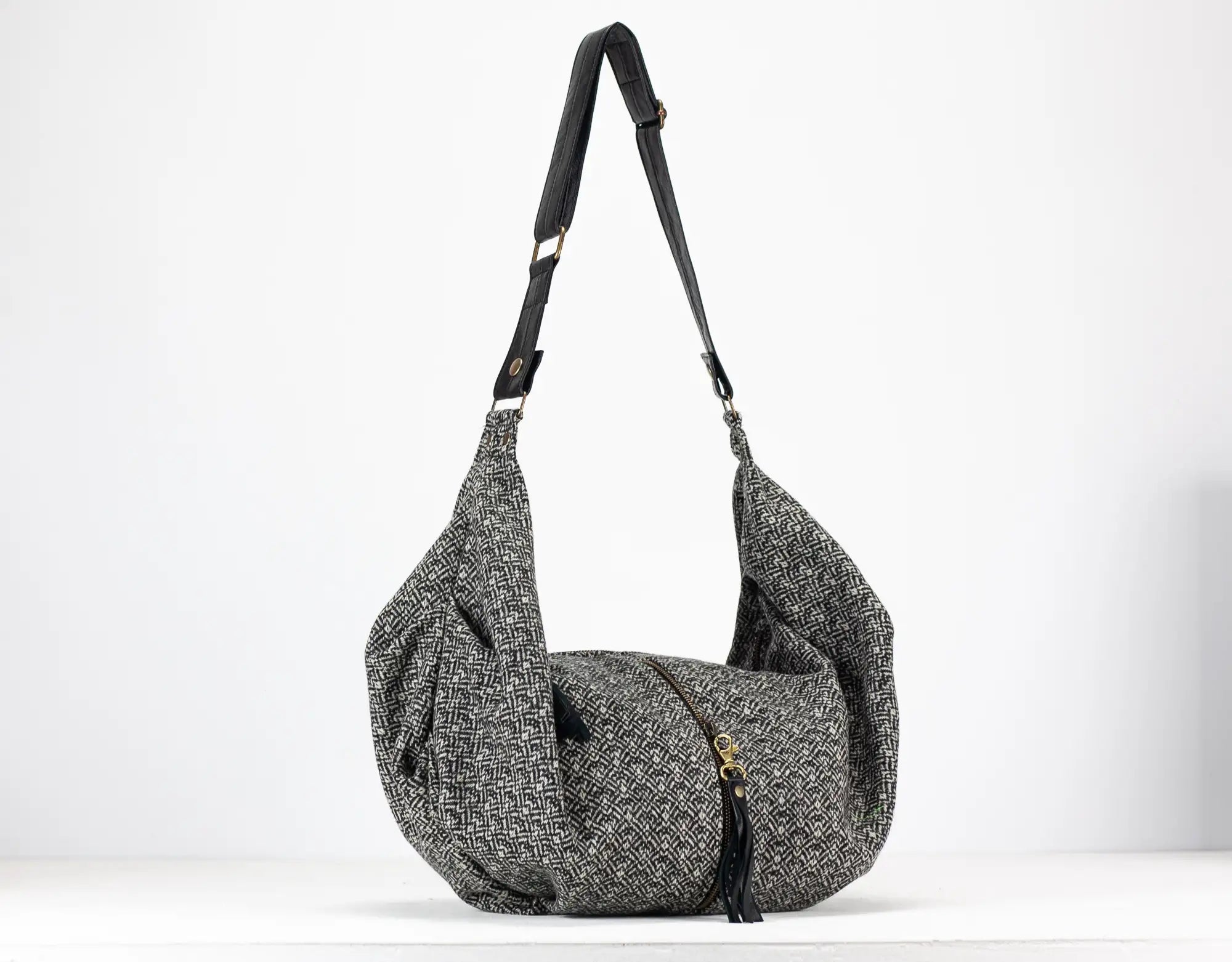 Gray textured shoulder bag with a strap on a white background