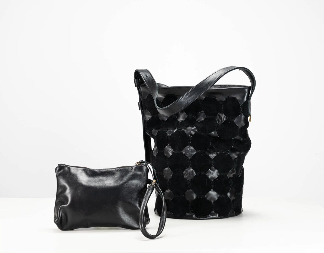 A black leather shoulder bag with a distinctive textured honeycomb pattern and a matching small black leather wristlet pouch, displayed on a clean white background.