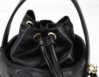 Black leather bucket bag with drawstring on a white background