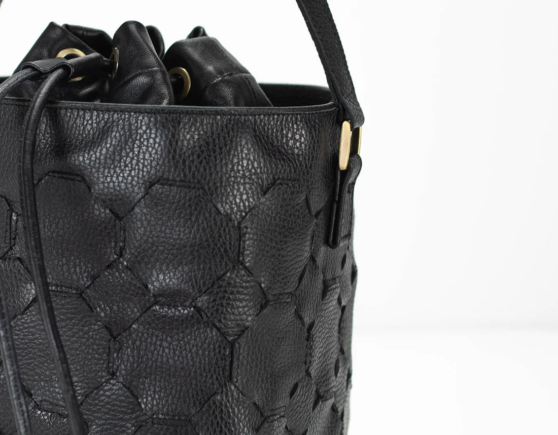 Black textured handbag with a strap on a white background