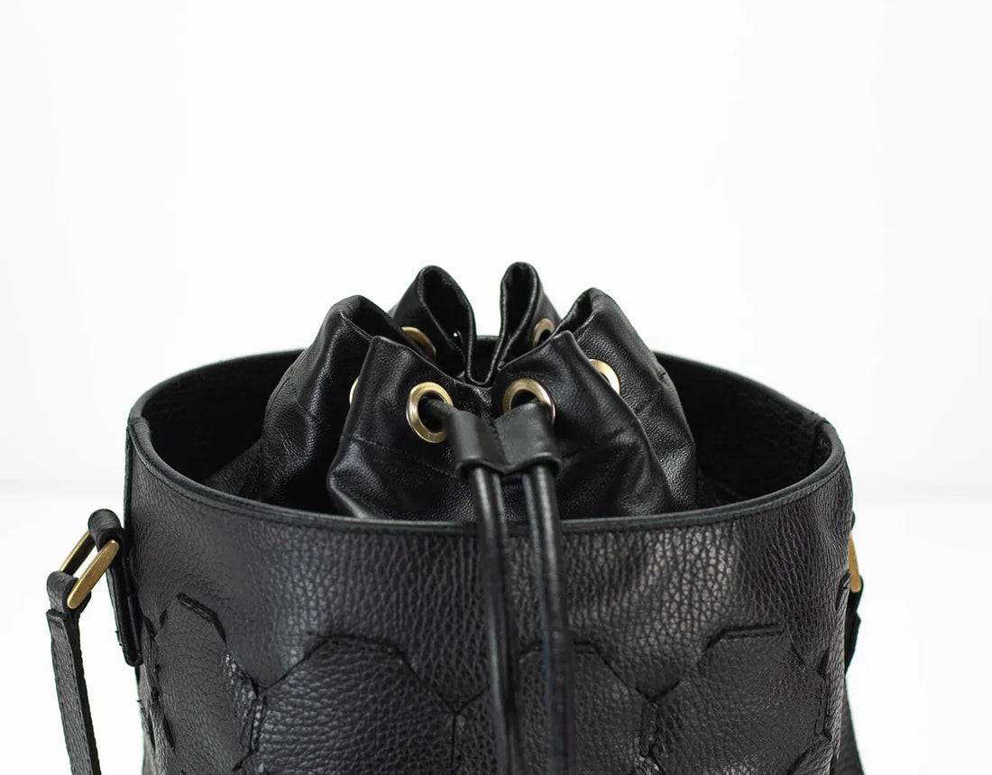 Black leather bucket bag with drawstring on a white background