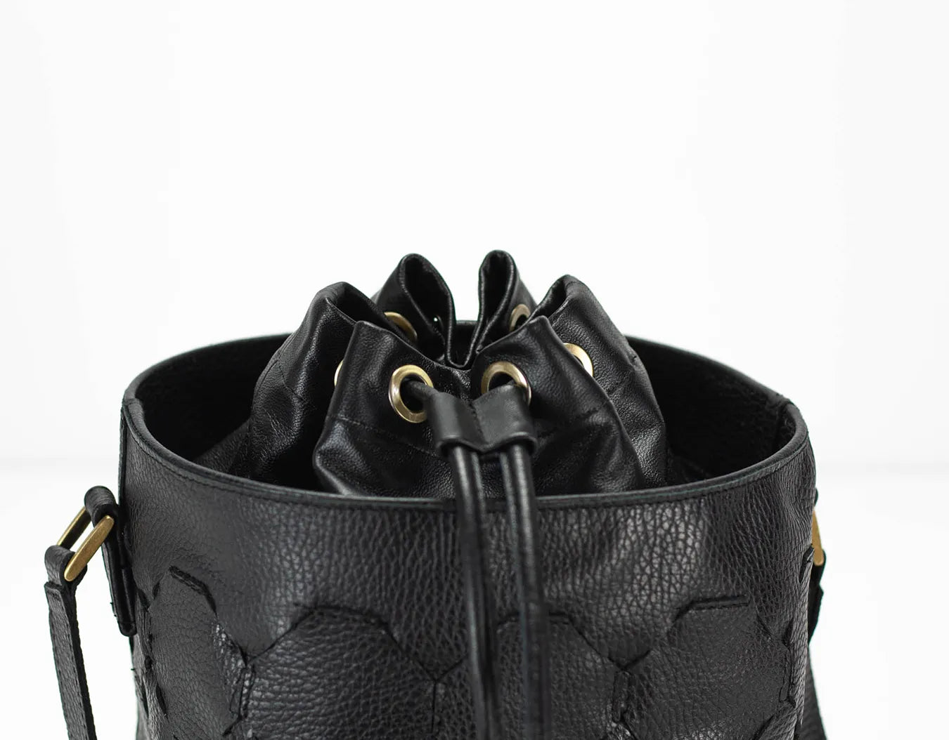 Black leather bucket bag with drawstring on a white background