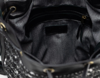 Close-up of a black handbag with studded details on a dark background